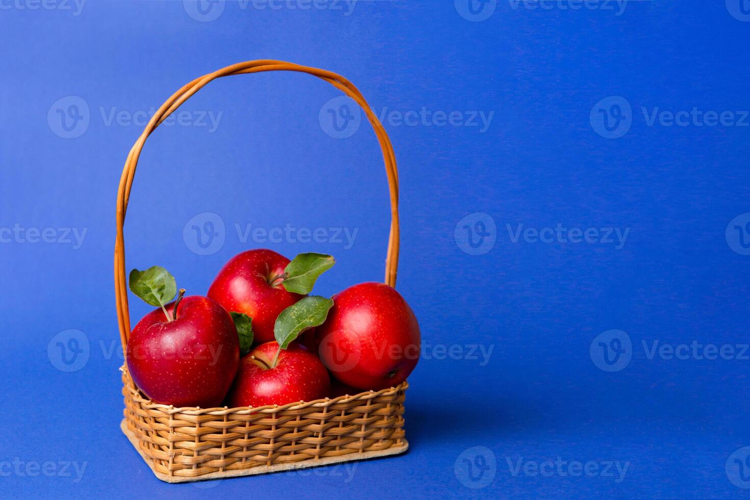 Ripe garden apple fruits with leaves in basket on wooden table. Top view flat lay with copy space photo