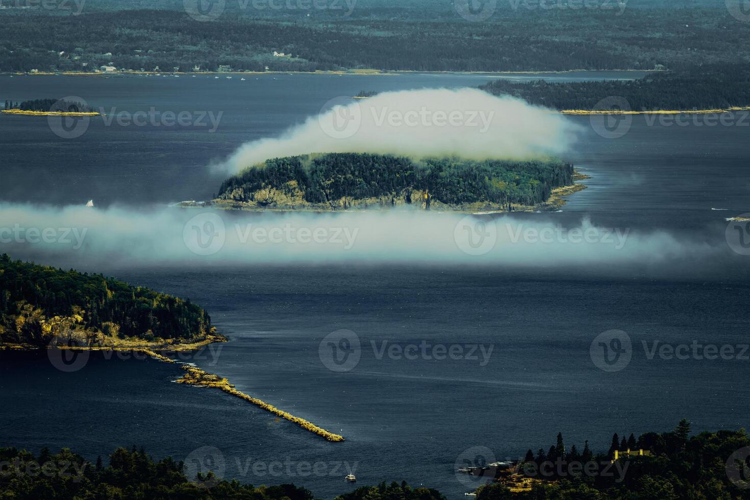 Over the island, close to the shore, are clouds photo