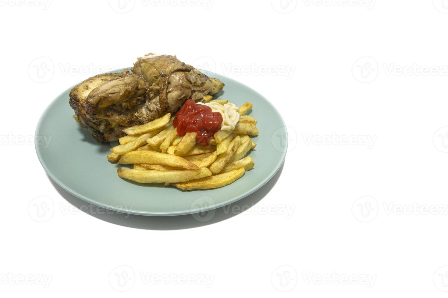 Roasted chicken with French fries, topped with ketchup and mayonnaise, served on a turquoise plate. Isolated on a white background. photo