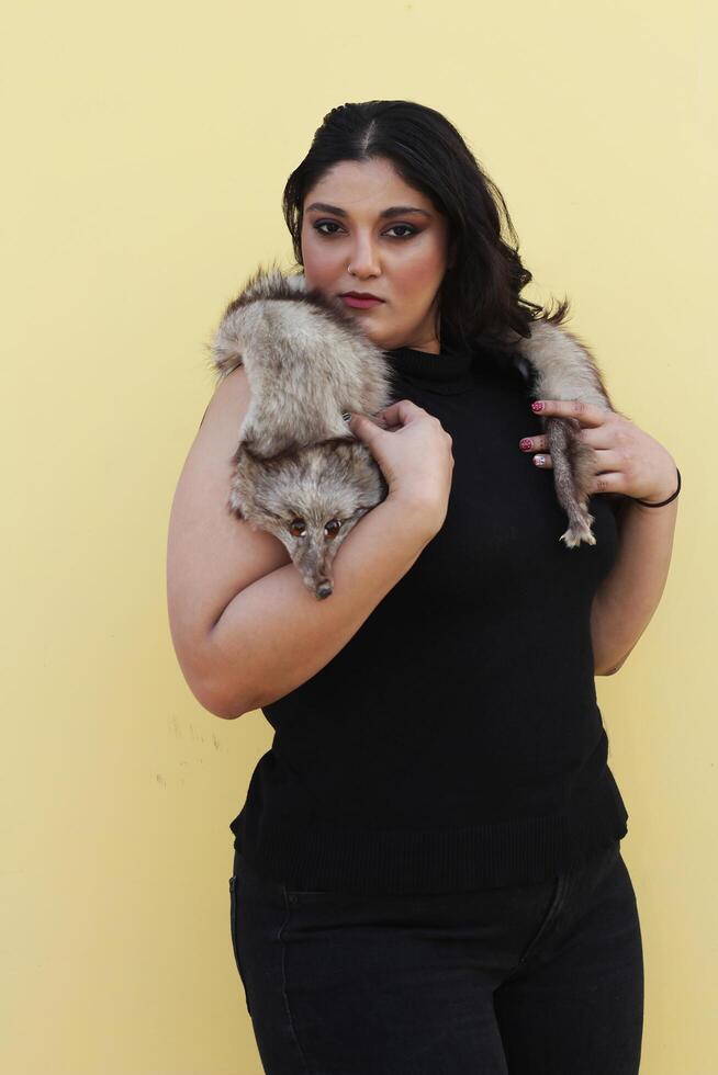 a woman holding a small furry animal in her arms photo