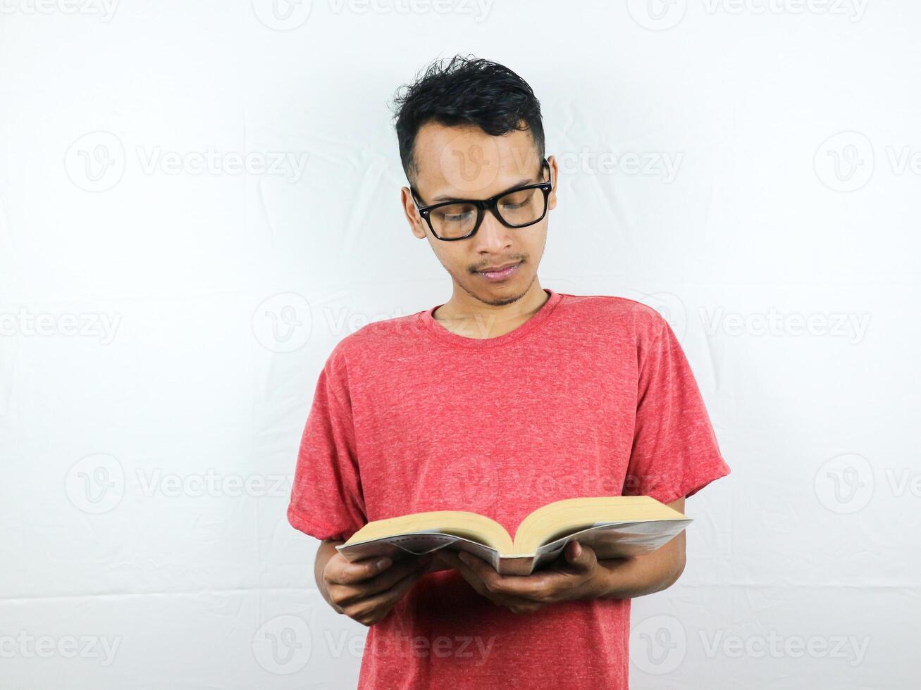 retrato de asiático hombre participación libro con leyendo enfocado expresión. foto