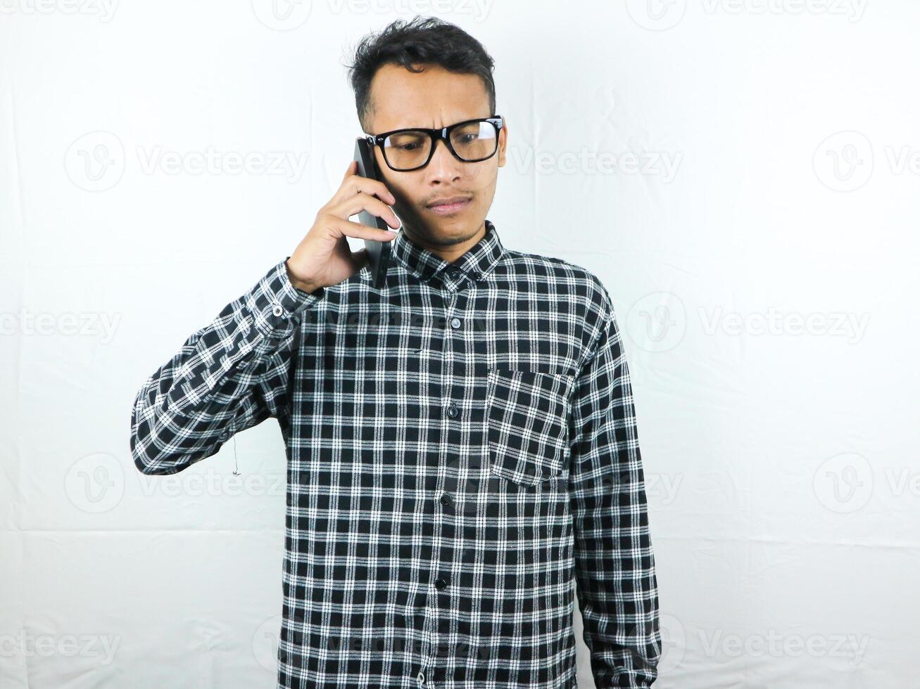 Portrait of asian man talking on phone with angry face expression. photo