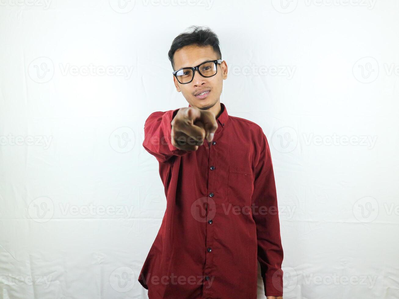 Angry handsome man pointing index finger at you on white isolated background, looking at camera photo