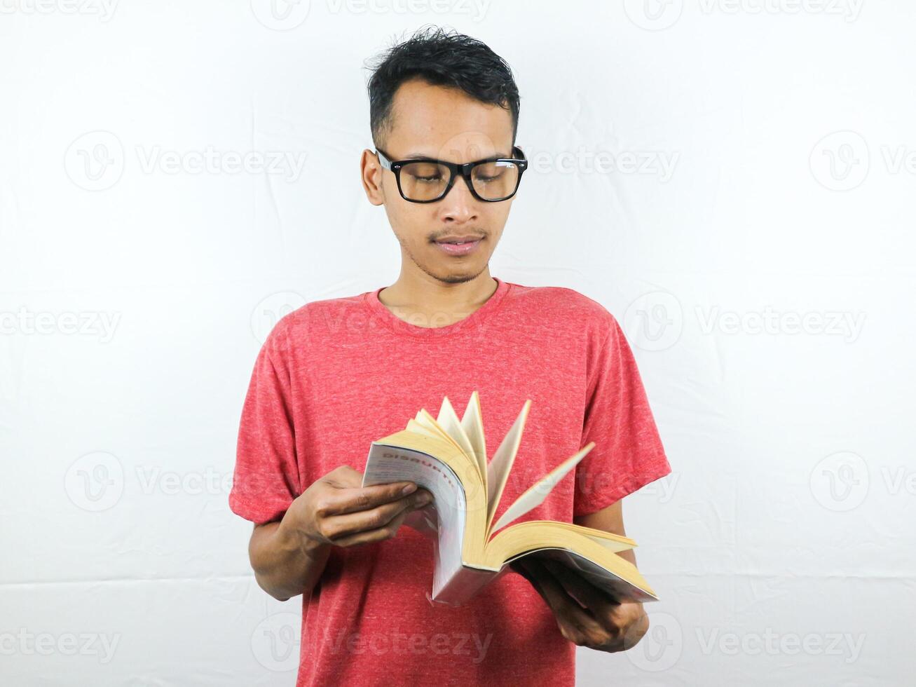 portrait of asian man holding book with reading focused expression. photo