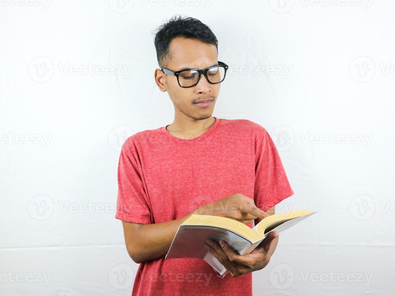 retrato de asiático hombre participación libro con leyendo enfocado expresión. foto