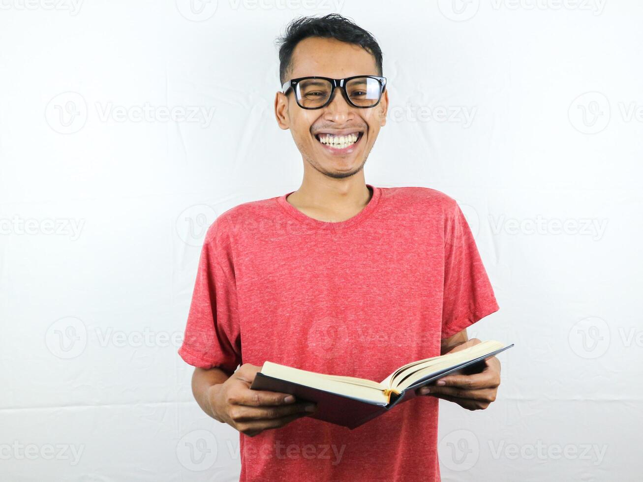 hermoso asiático hombre sonriente y participación y leyendo libro en mano foto