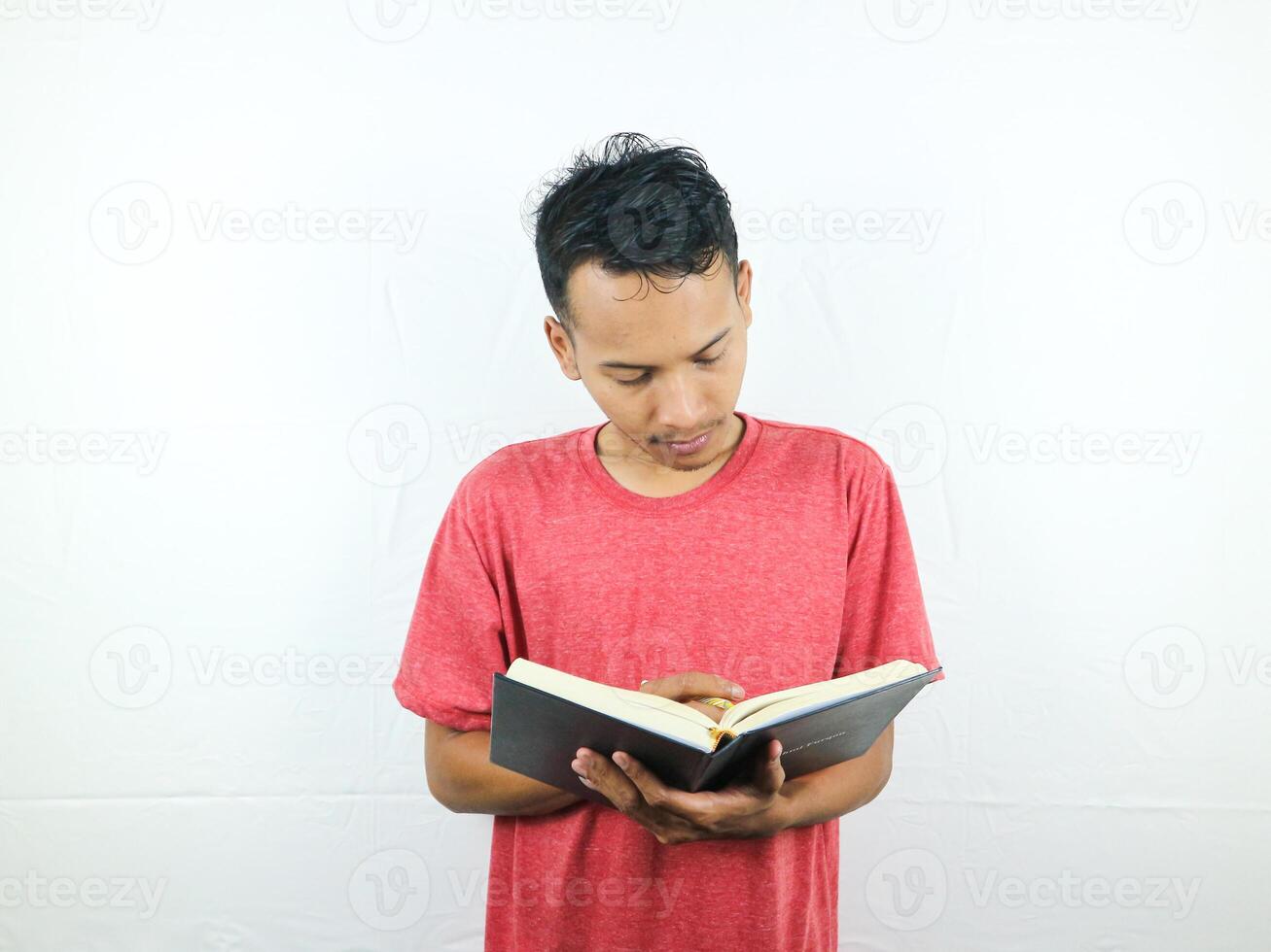 portrait of an asian man holding pen and writing book isolated on white background. photo