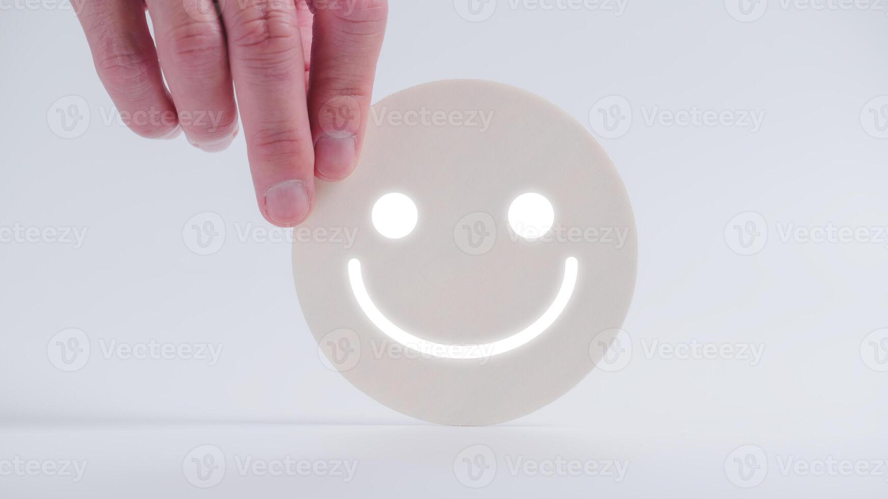 Customer service evaluation and satisfaction survey concepts. The client's hand picked the happy face smile face icon on circle wood photo