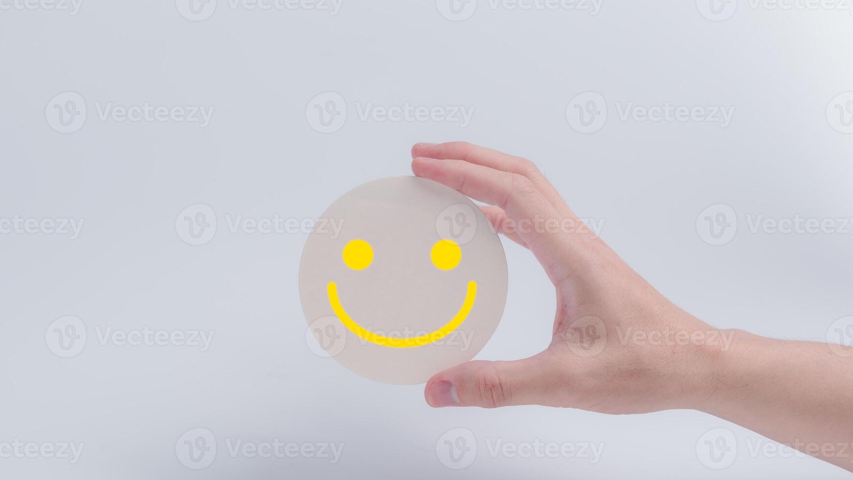 Customer service evaluation and satisfaction survey concepts. The client's hand holding  the happy face smile face icon on circle wood photo