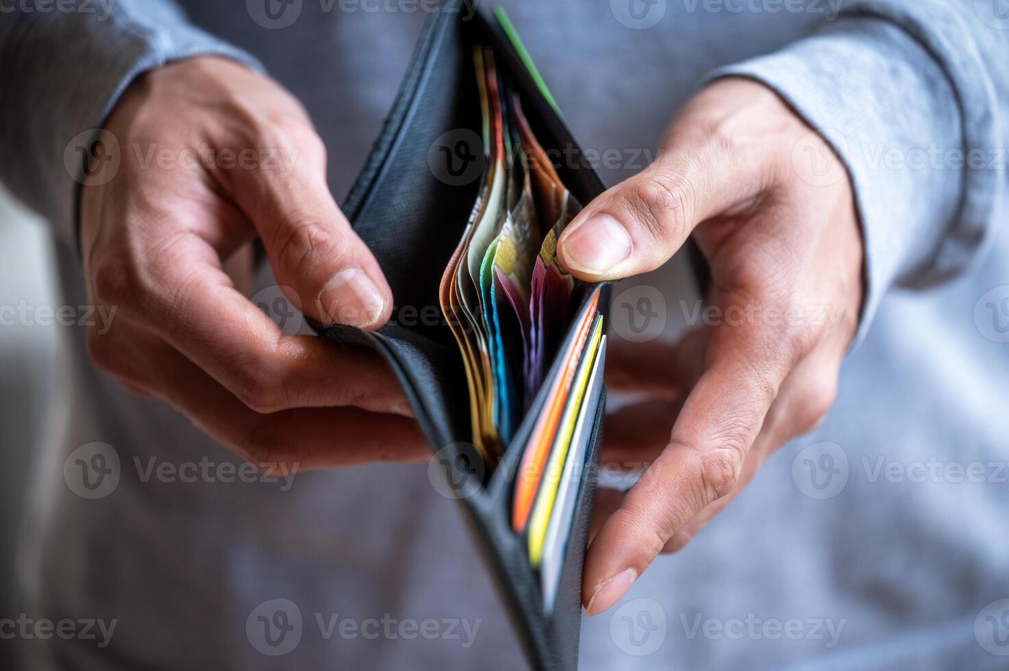 a man holding and openning wallet with some money and cards photo