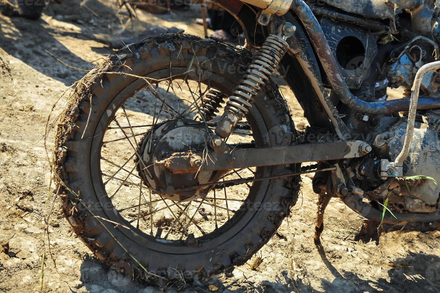 the rear wheel of a motorbike is dirty with mud photo