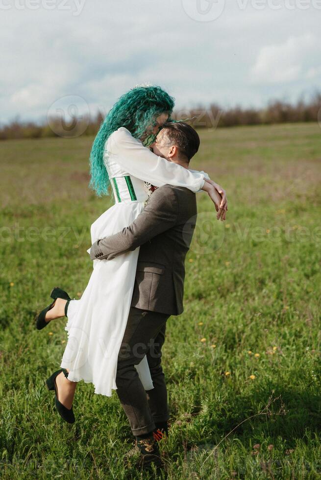 a bearded groom and a girl with green hair dance and twirl photo