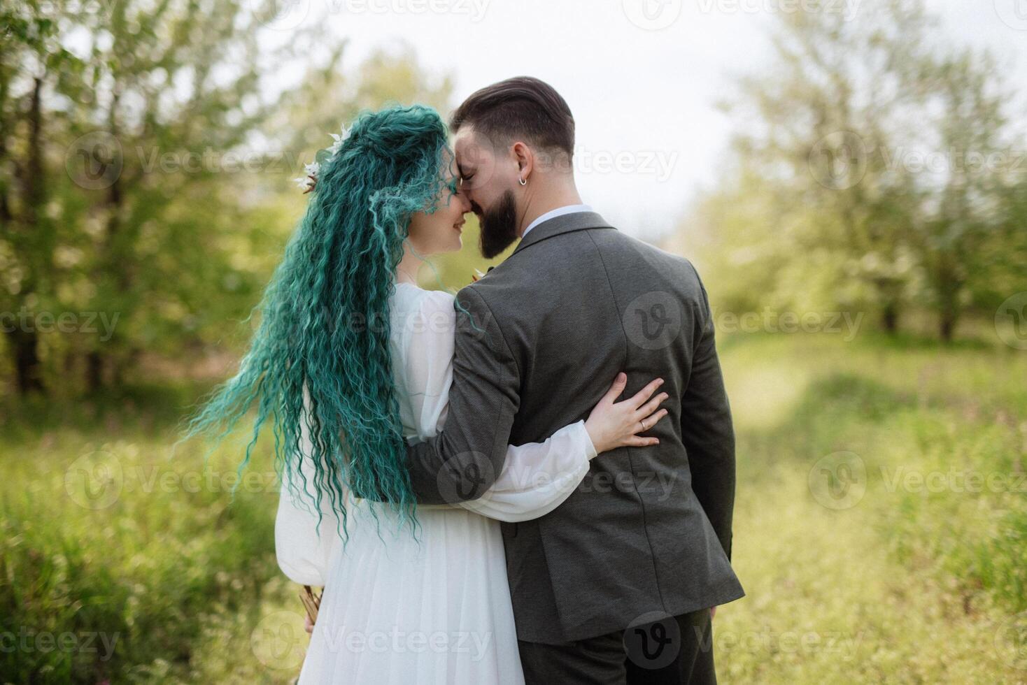 a bearded groom and a girl with green hair are walking photo