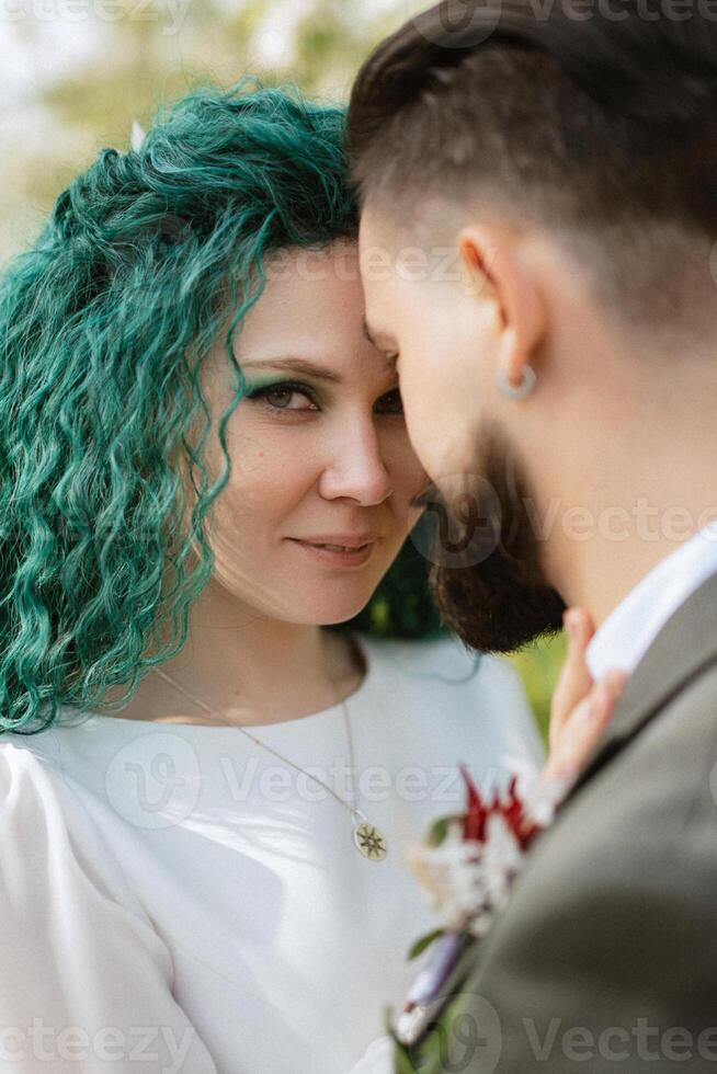 a bearded groom and a girl with green hair are walking photo