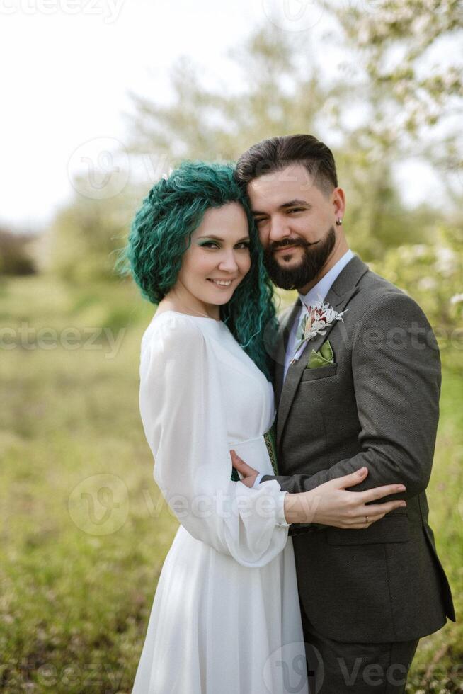 a bearded groom and a girl with green hair are walking photo