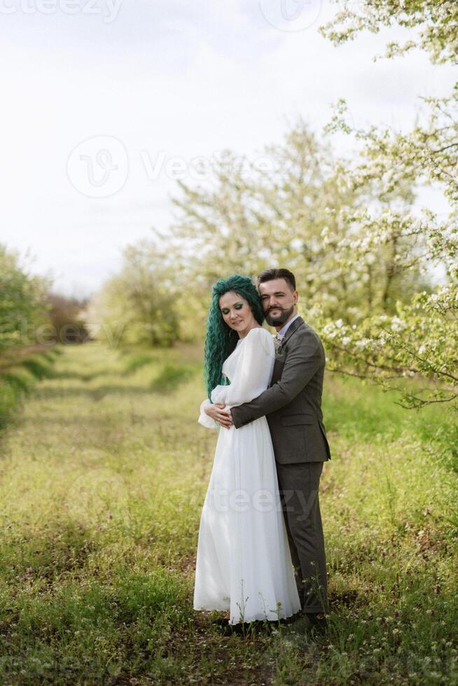 a bearded groom and a girl with green hair are walking photo