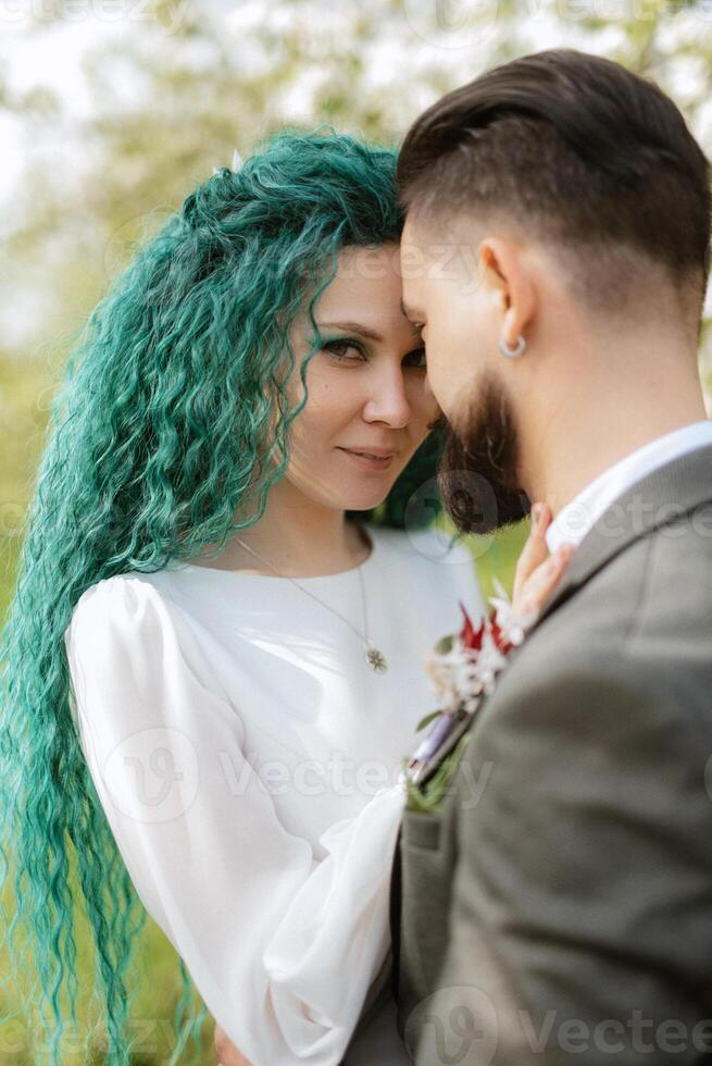 a bearded groom and a girl with green hair are walking photo