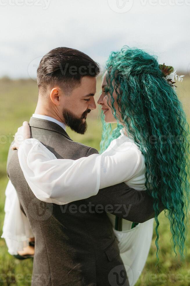 a bearded groom and a girl with green hair dance and twirl photo