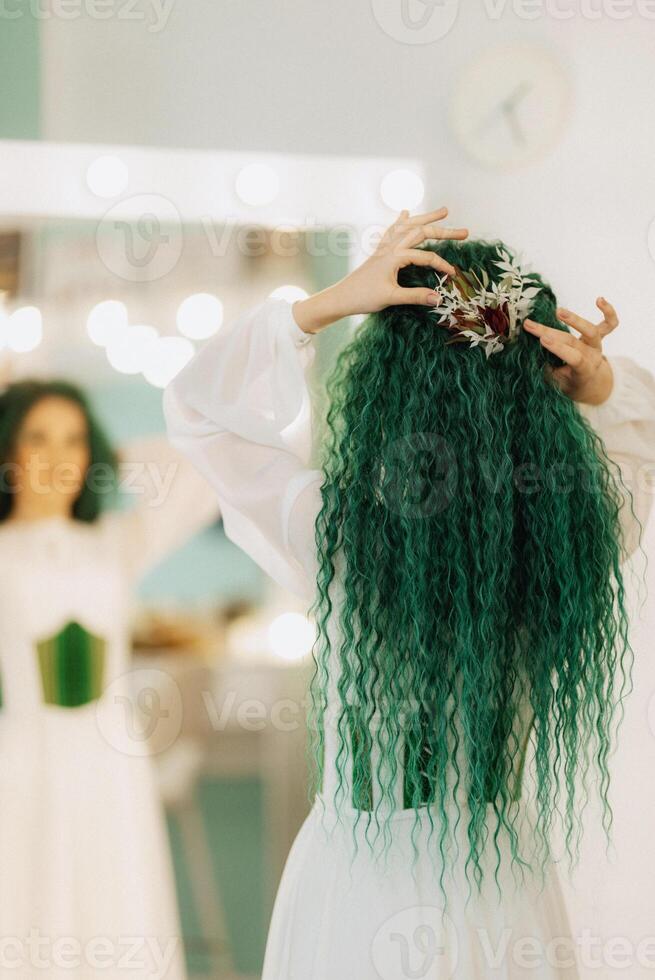 portrait of a bride with green curly hair in the beauty room photo