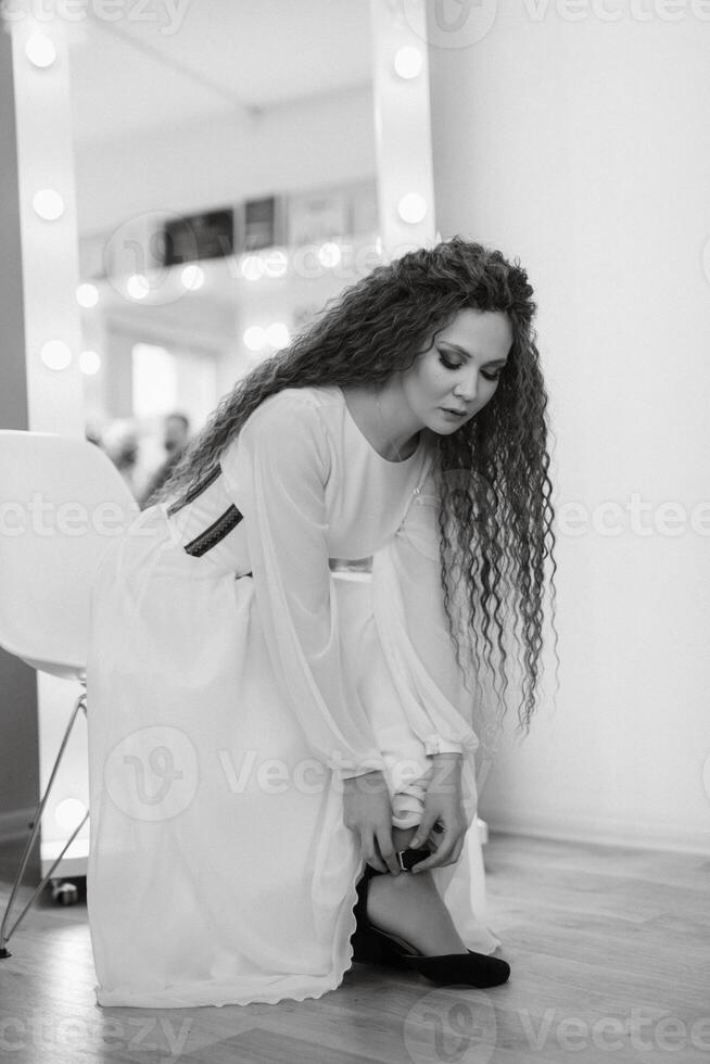 portrait of a bride with green curly hair in the beauty room photo
