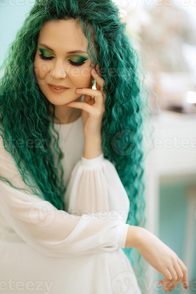 portrait of a bride with green curly hair in the beauty room photo