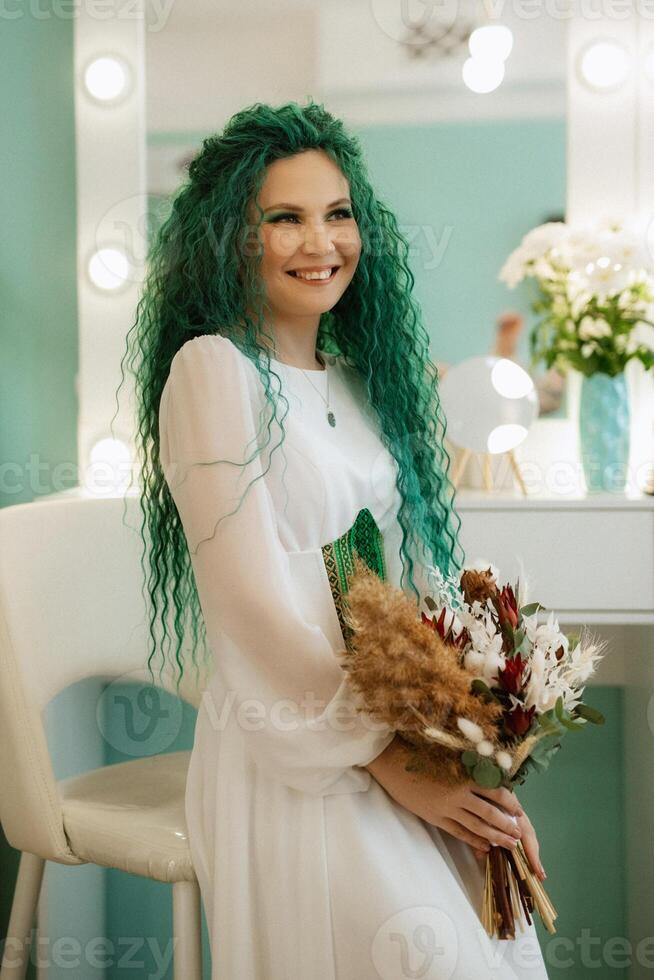 portrait of a bride with green curly hair in the beauty room photo