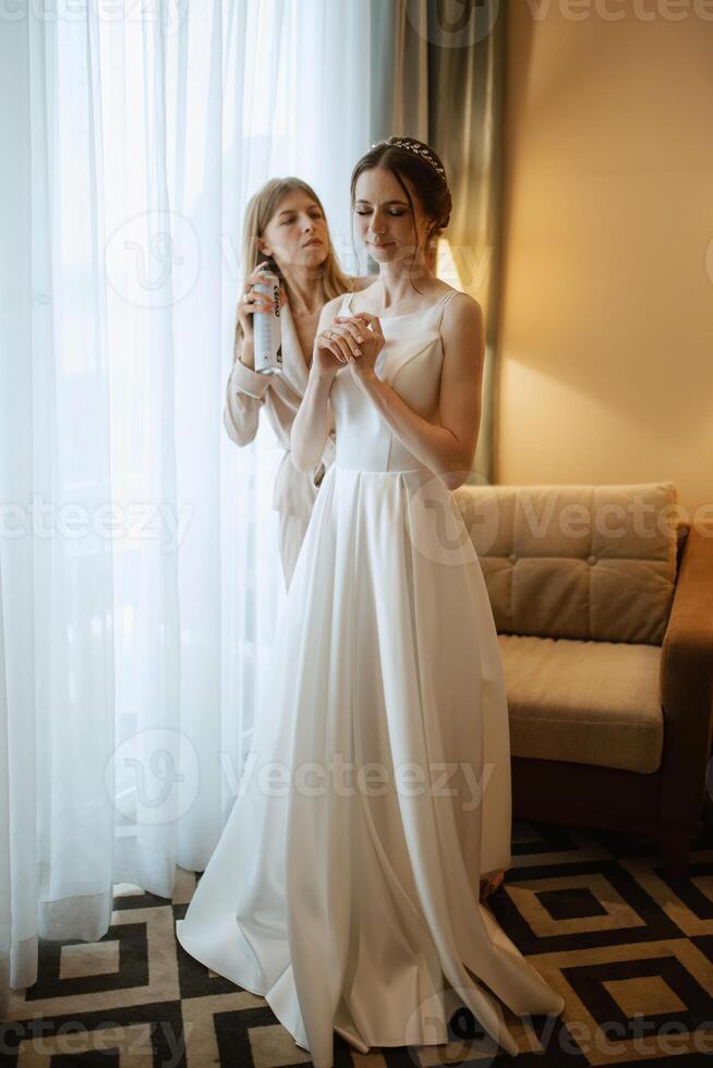 preparations for the bride with the dressing of the wedding dress photo