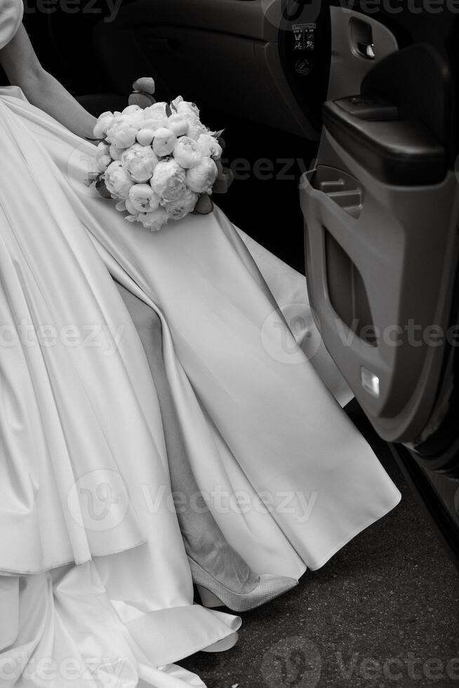 bride with a black car near a glass skyscraper photo