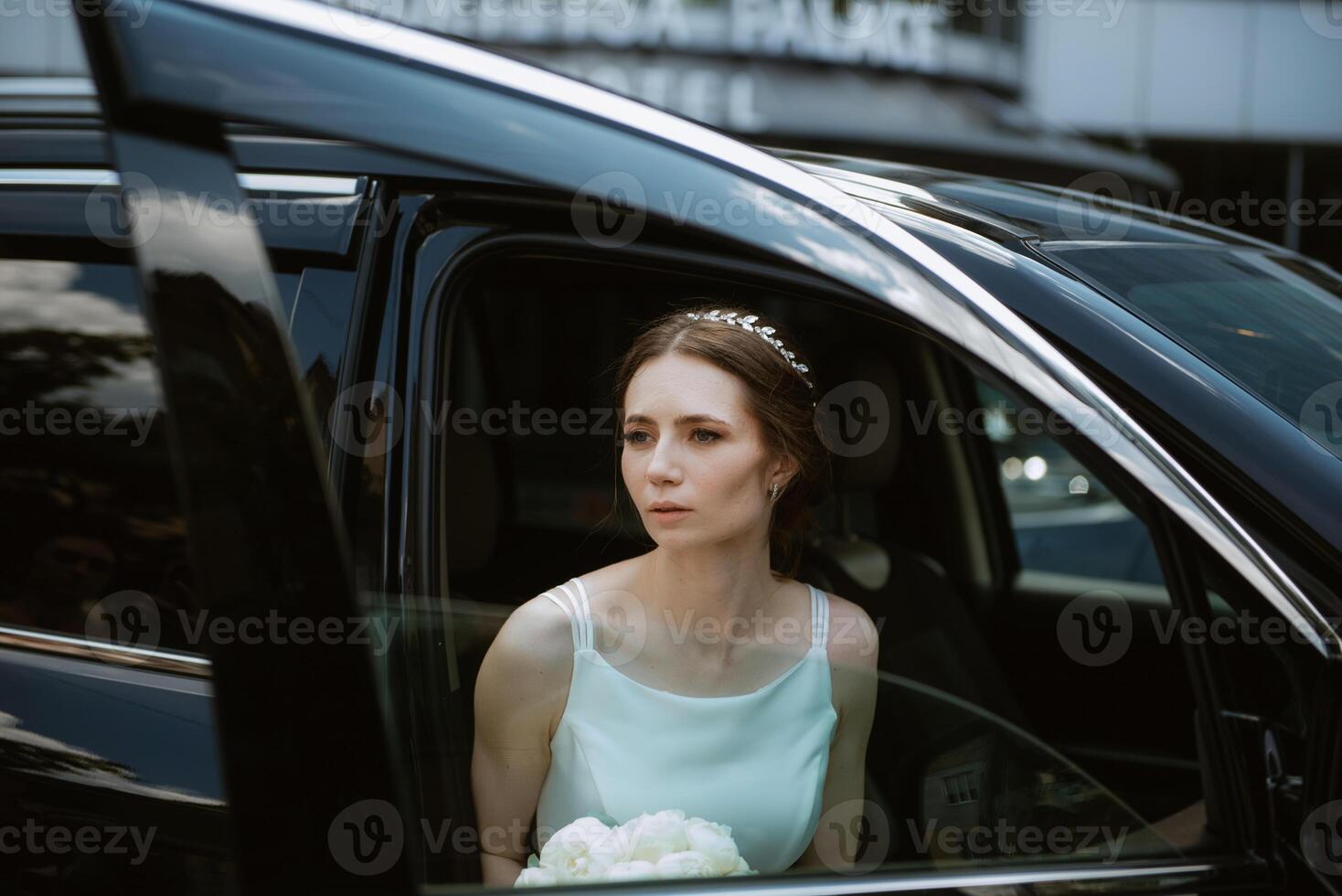 novia con un negro coche cerca un vaso rascacielos foto