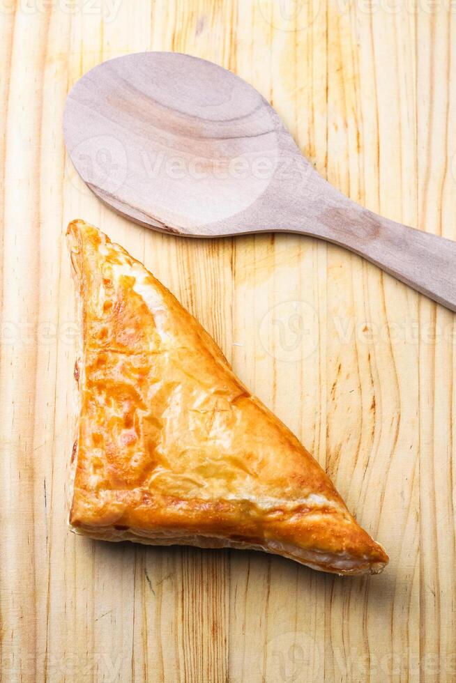 Chicken Pie or Baklava on wooden board and wood spoon on white background photo