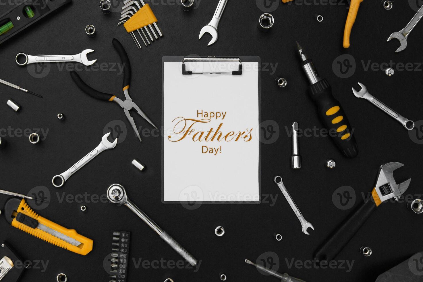 Lettering Happy Father's Day with many different tools for repair work on a black table. photo