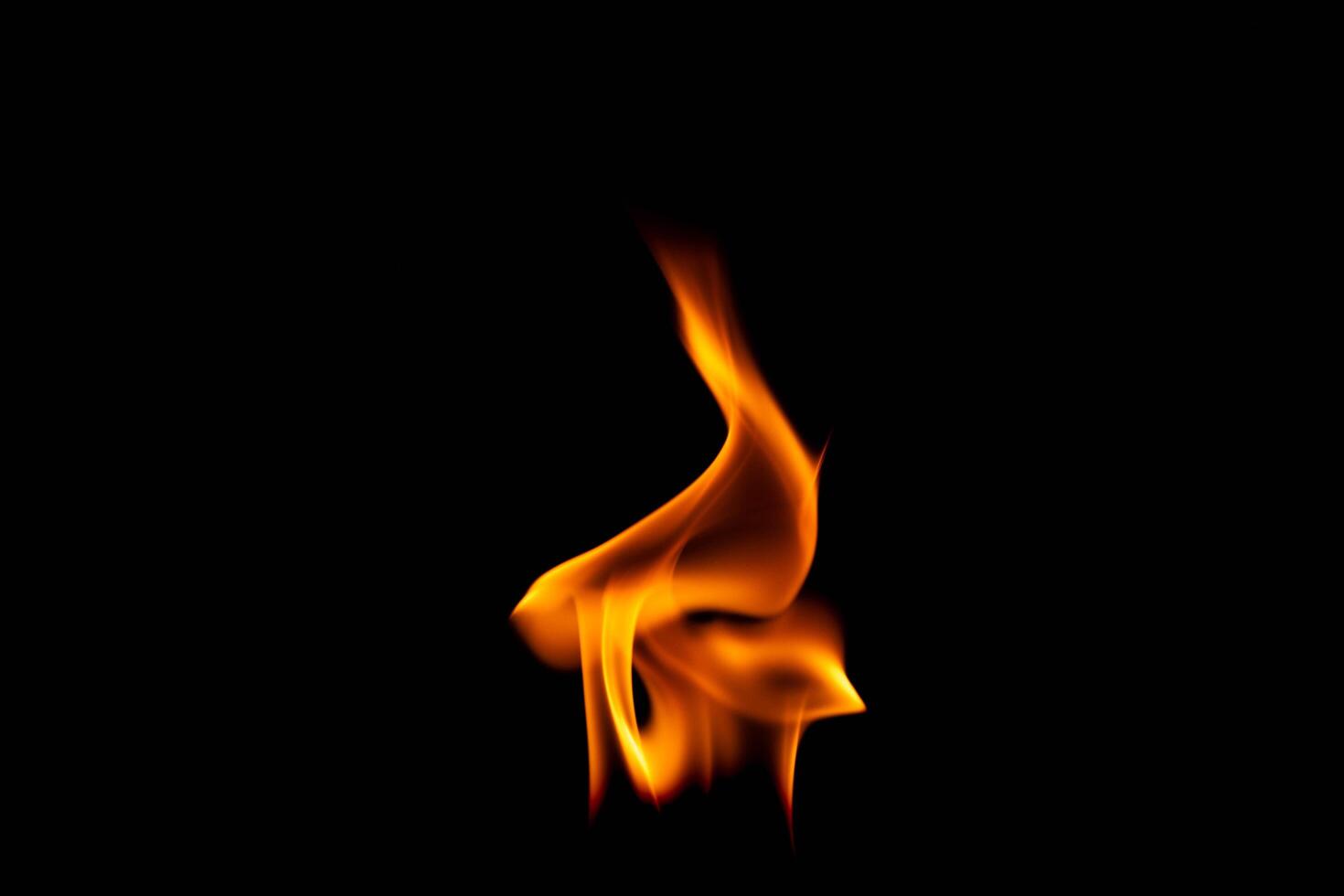 caliente llamas en un negro antecedentes. hermosa fuego de fuego en el oscuro. resumen de ardiente llamas y fumar. foto