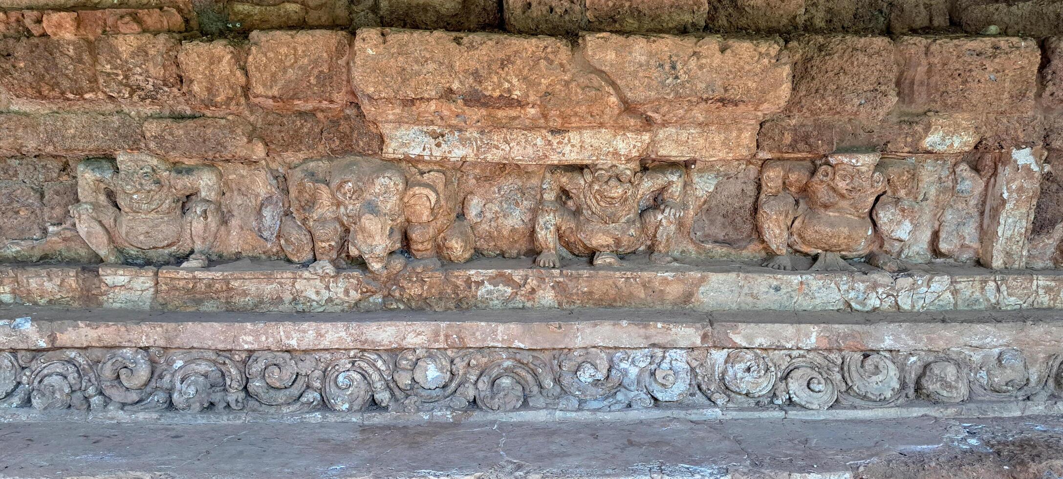 mythology statues on the stone wall in southeast Asia archaeological site photo