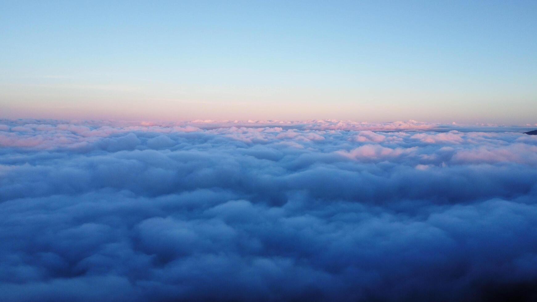 Aerial view over the mountains with sea of fog during morning sunrise in blue sky. Sea of clouds around mountain peaks at sunrise. Unseen travel in Northern Thailand photo