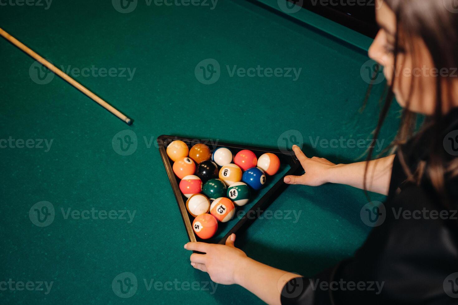 el niña pone fuera de billar pelotas a comienzo el juego en el de billar club .jugando piscina foto