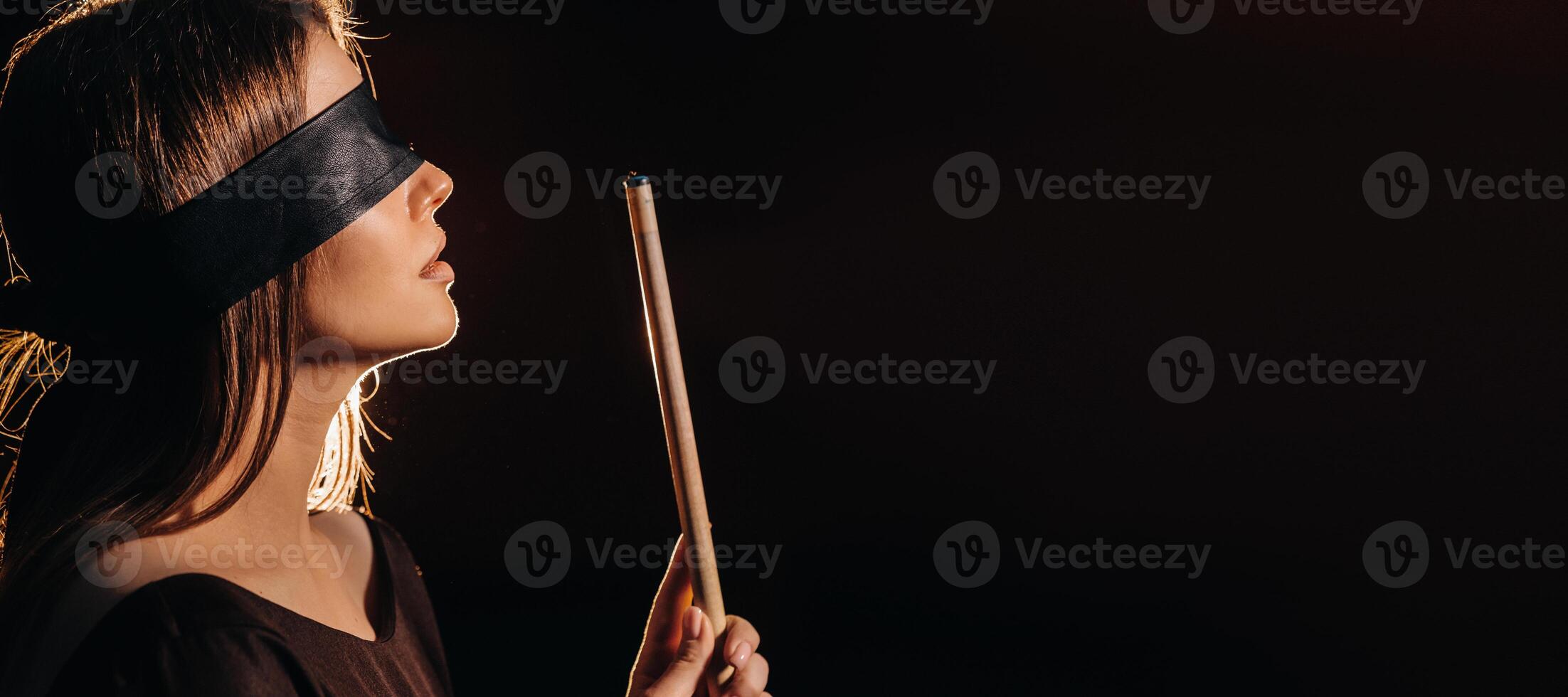 A girl with a blindfold and a cue in her hands in a billiard club.Russian billiards photo