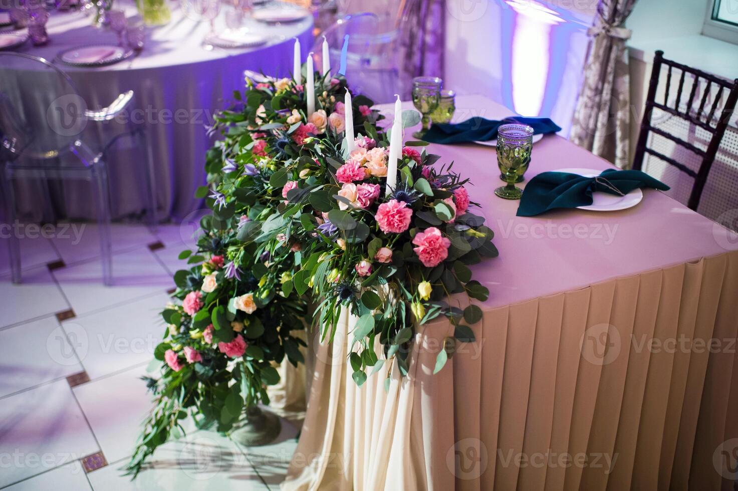 Wedding bride and groom table presidium decorated with a lot of flowers photo