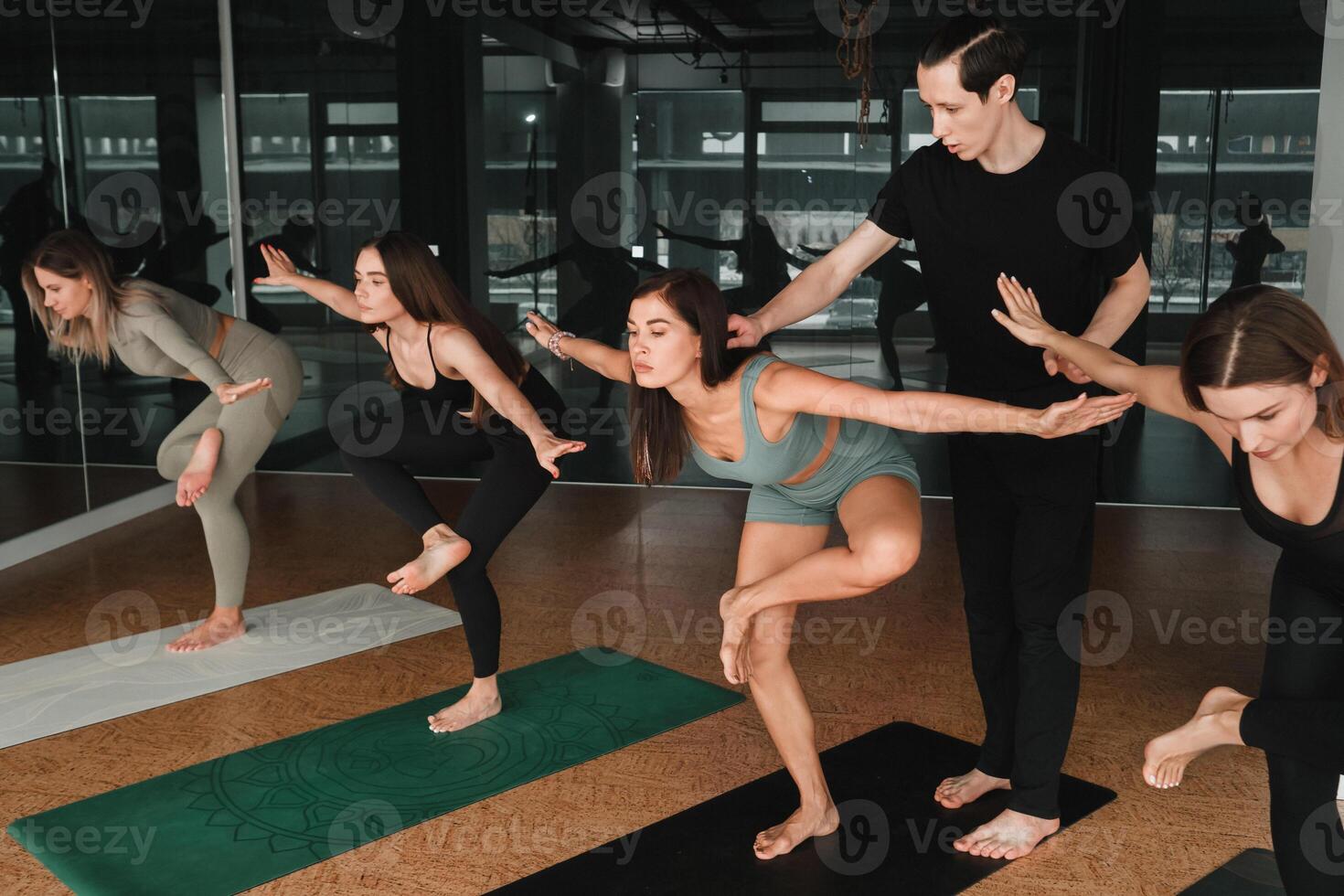un grupo de muchachas hacer yoga en el gimnasio debajo el Guia de un entrenador foto