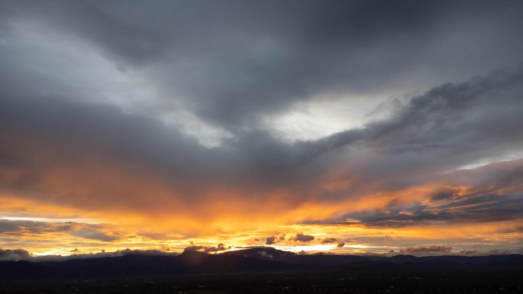 Real amazing sunrise or sunset sky with gentle colorful clouds. Beautiful natural sunset of the mountain range under colorful blue and orange sunset in the evening. photo