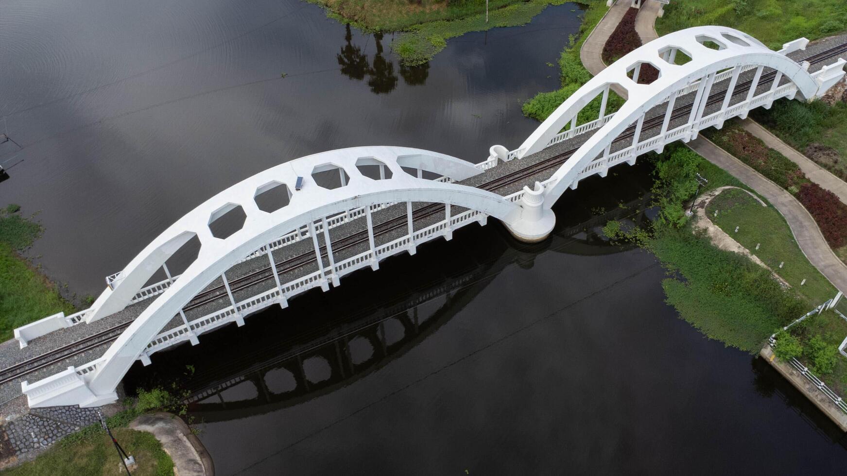 aéreo ver de eso chomphu blanco puente, lamphun, tailandia antiguo ferrocarril puente terminado río con naturaleza fondo, bosque y verde montañas. turista atracción punto de referencia. foto