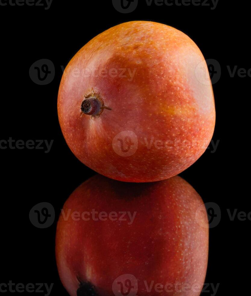 Ripe and sweet mango Close up on a black background creating a beautiful reflection photo