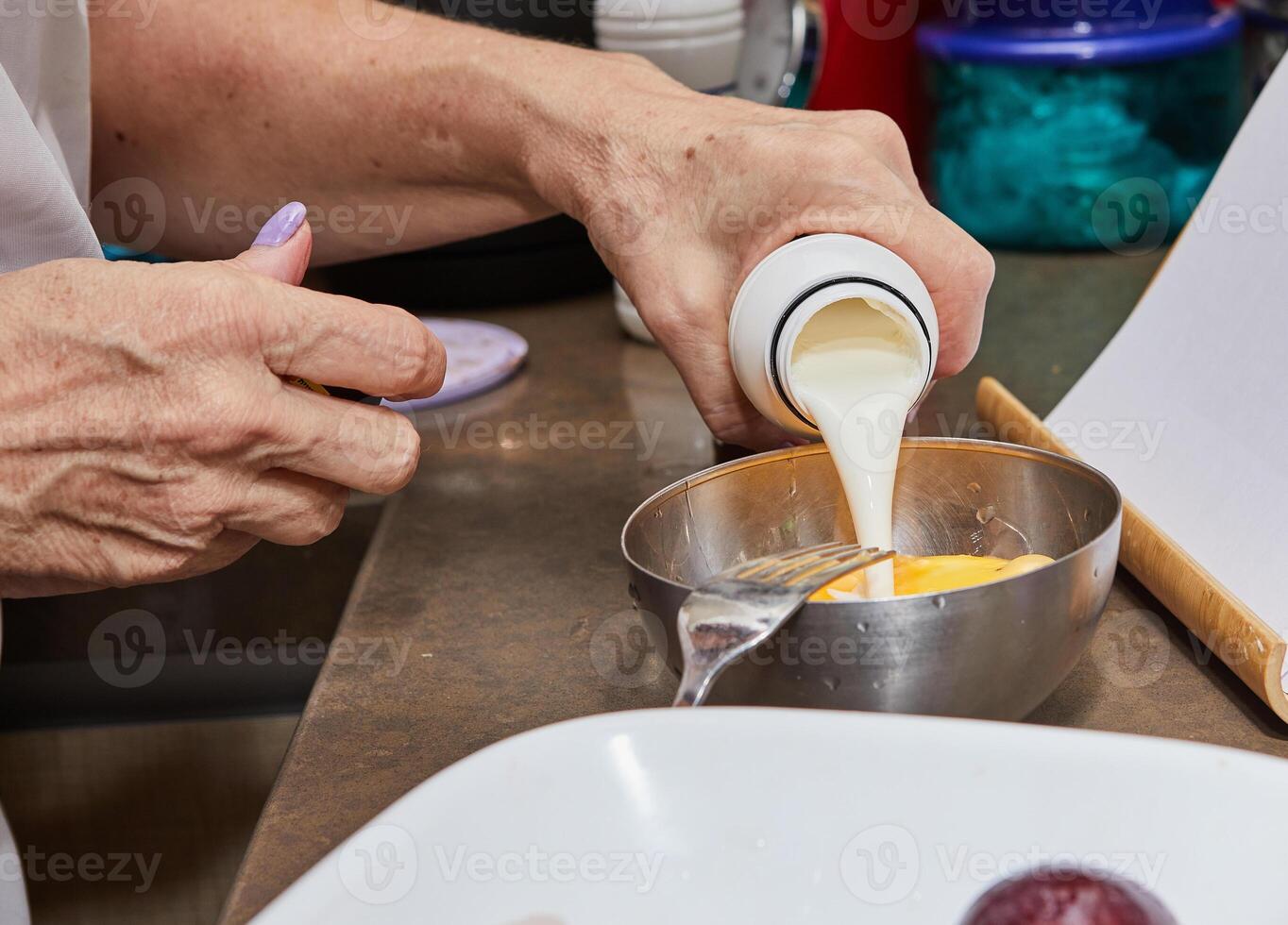 del chef manos torrencial crema dentro un cuenco con mezcla para Cocinando a hogar cocina foto