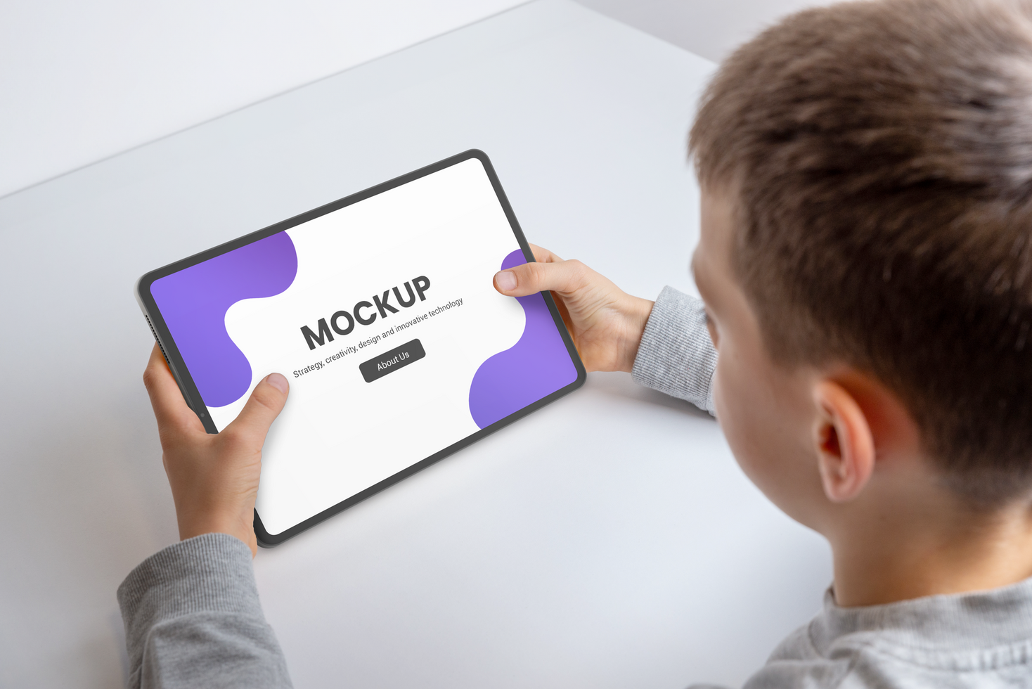 Boy at work deskwith tablet mockup for game or app promotion psd