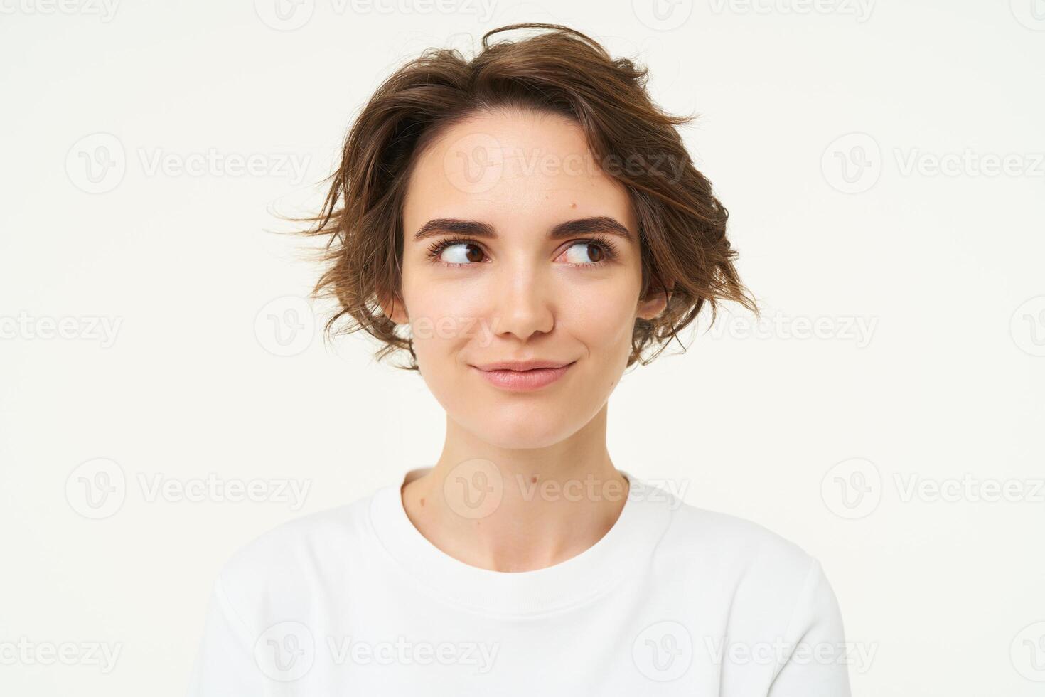 Close up portrait of brunette girl with short haircut, smiling and looking happy, posing over white background photo