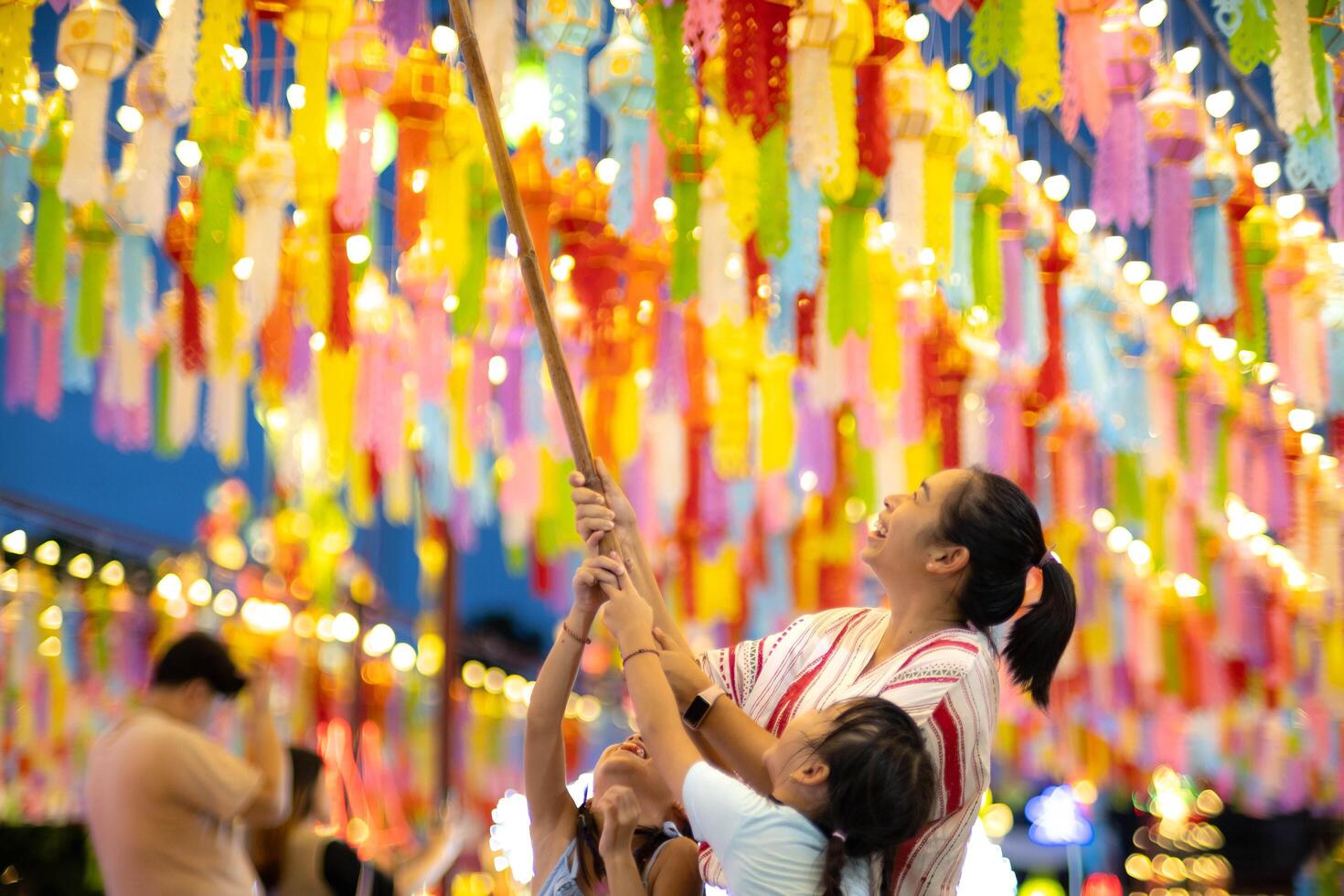 asiático familias hacer deseos y colgar linternas durante el cien mil linterna festival o yi peng festival en del Norte tailandia foto