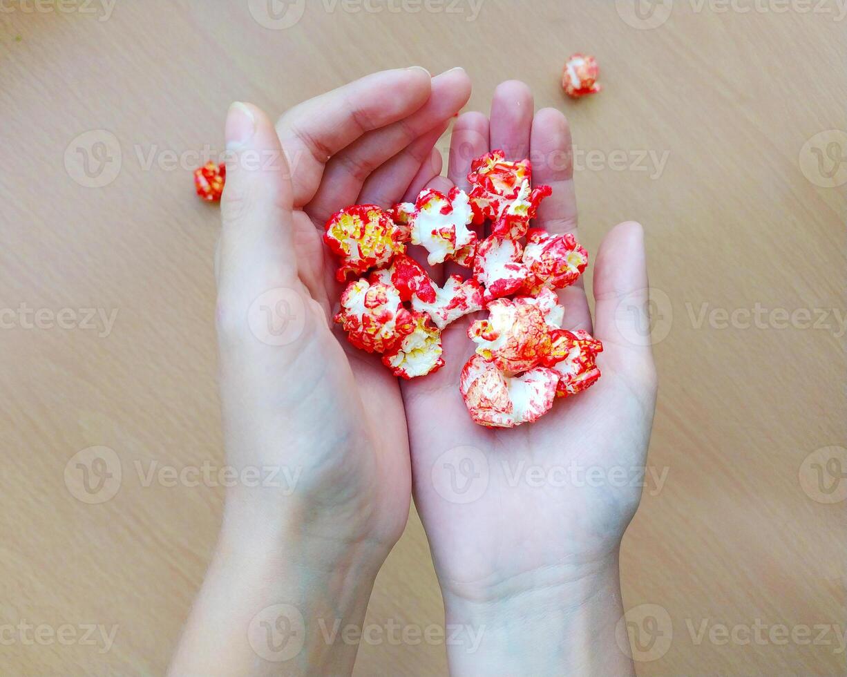 Close up of hands holding colored trendy popcorn. photo