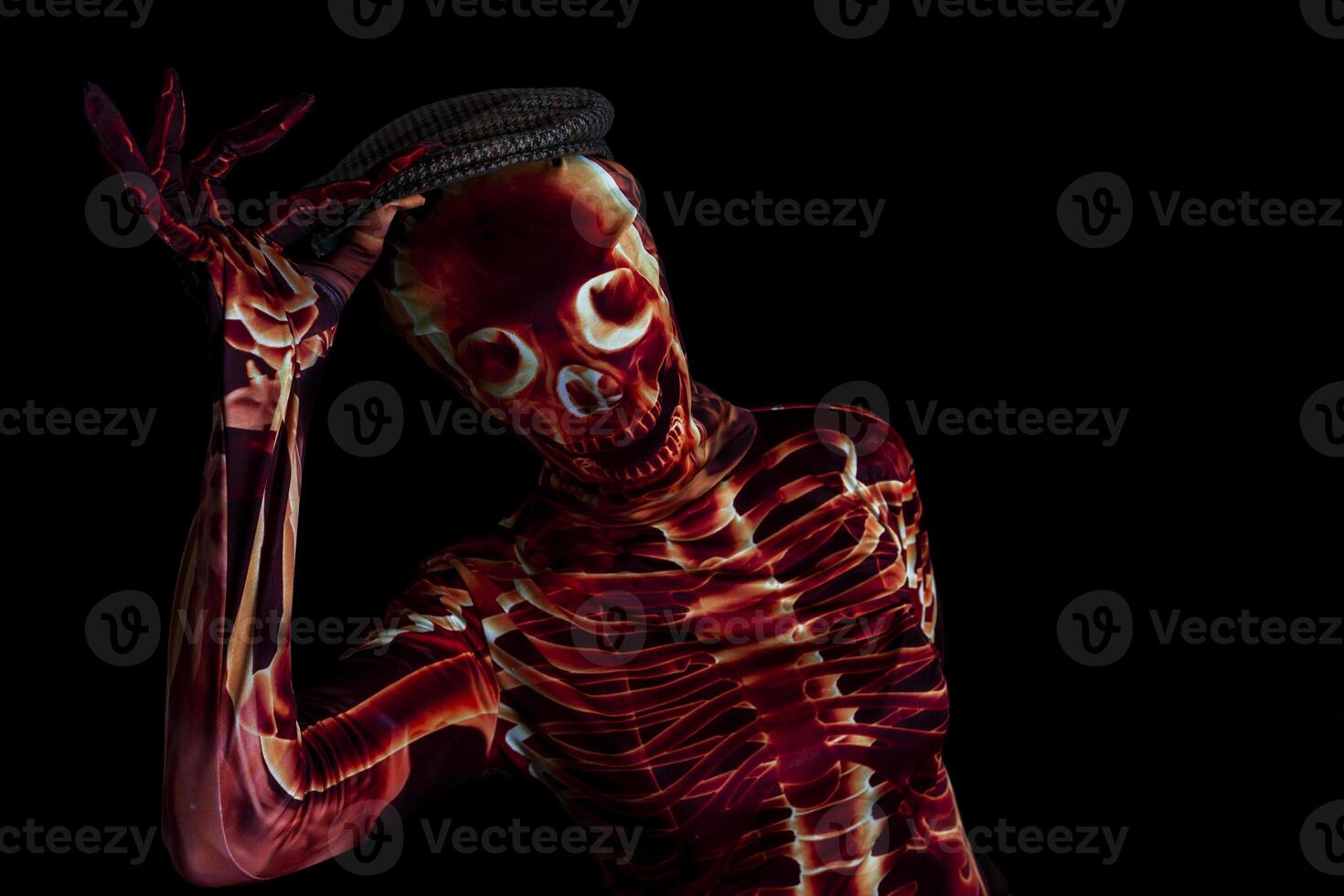 sensual woman dressed in a skeleton costume greets by raising her hat photo