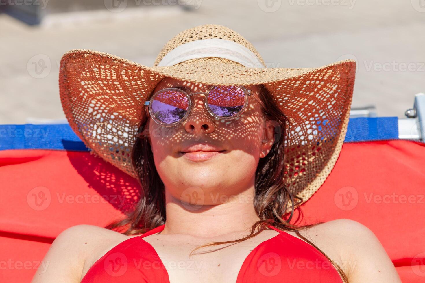 young woman in swimsuit while tanning on a lounger photo