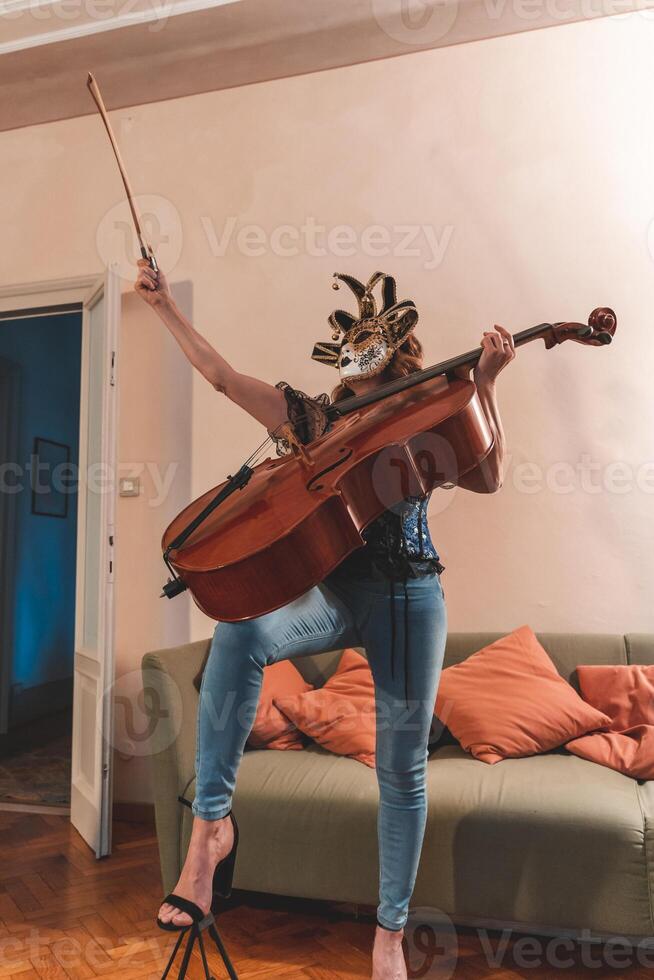 attractive woman wearing a mask is playing a cello photo