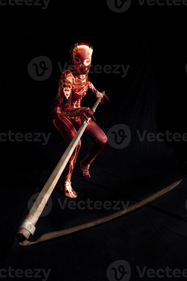 sensual woman dressed in a skeleton costume holding a farmer sickle photo